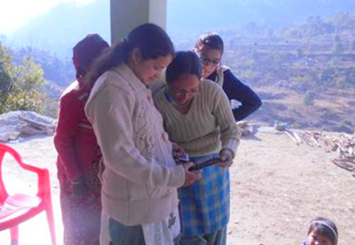 Trainer teaches the village women to operate a tablet