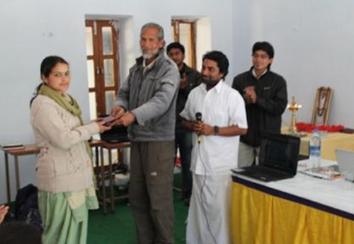 Sri. Om Prakash Gupta, Principal of Himalayan School of Life presenting a tablet to Smt. Mamta Bhat, village head of Astal village